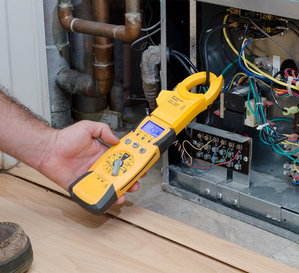 HVAC technician checking the amperage on a residential heat pump