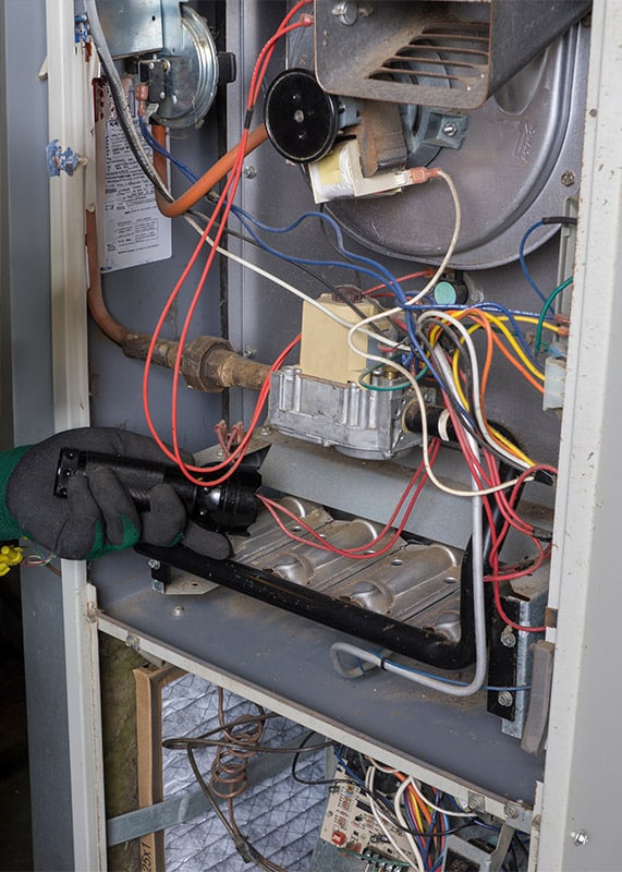 Technician looking over a gas furnace