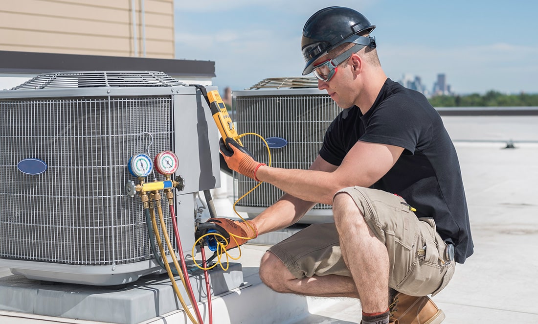 HVAC technician testing an air conditioner with specialized equipment