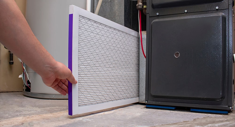 Technician changing an HVAC system filter